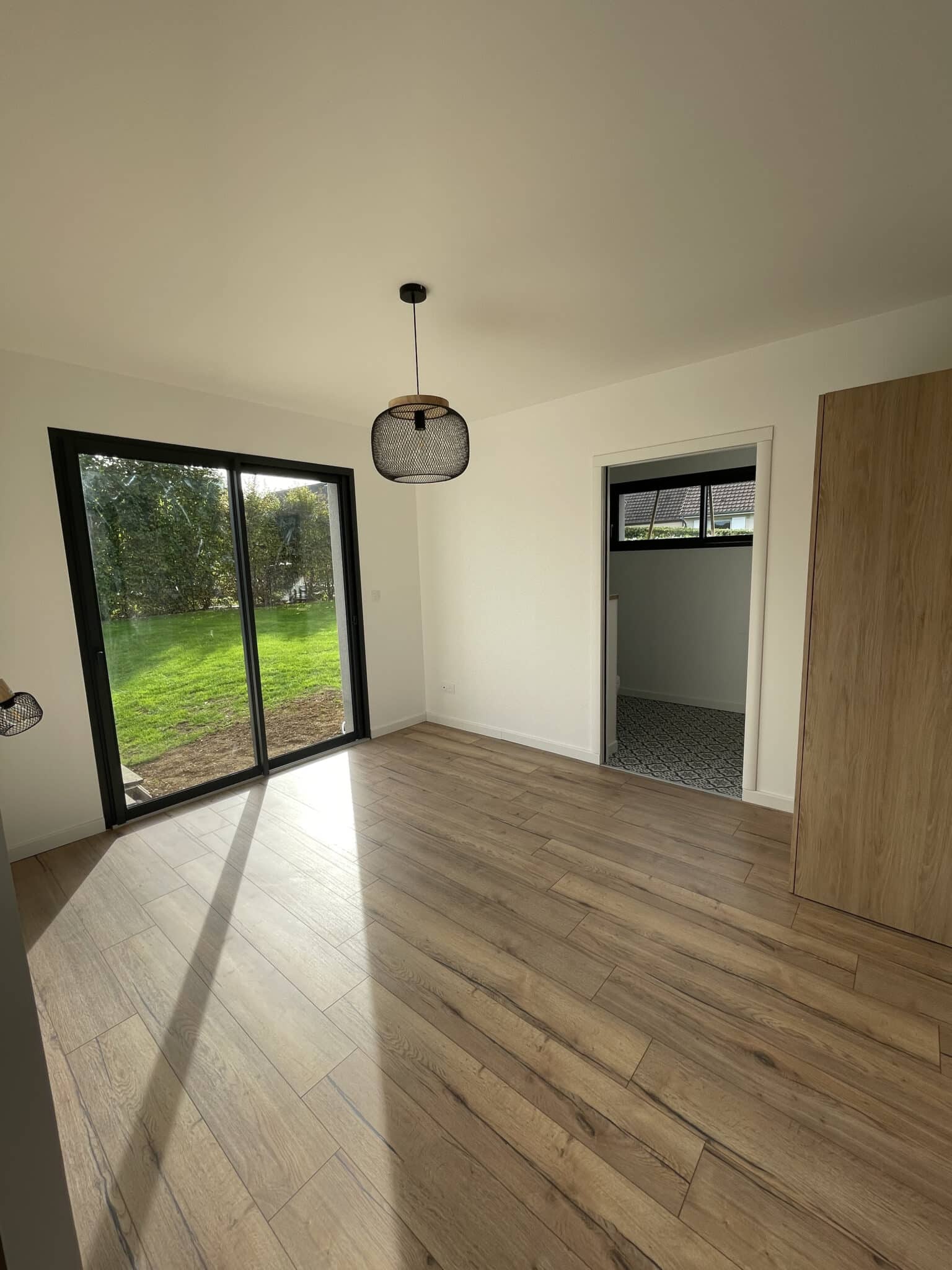 Pièce de vie avec baie vitrée et parquet après extension